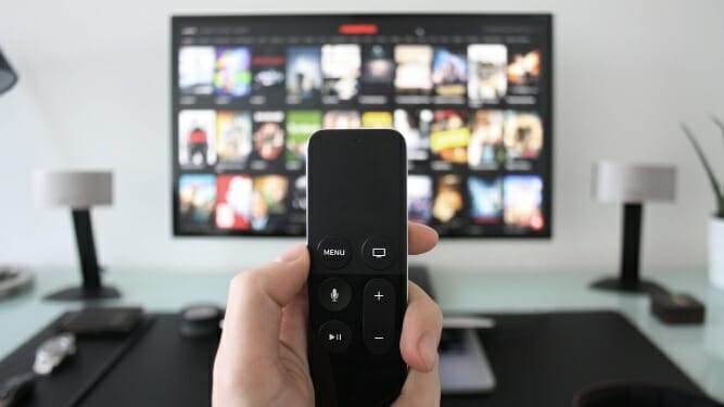 man holding remote control in front of tv