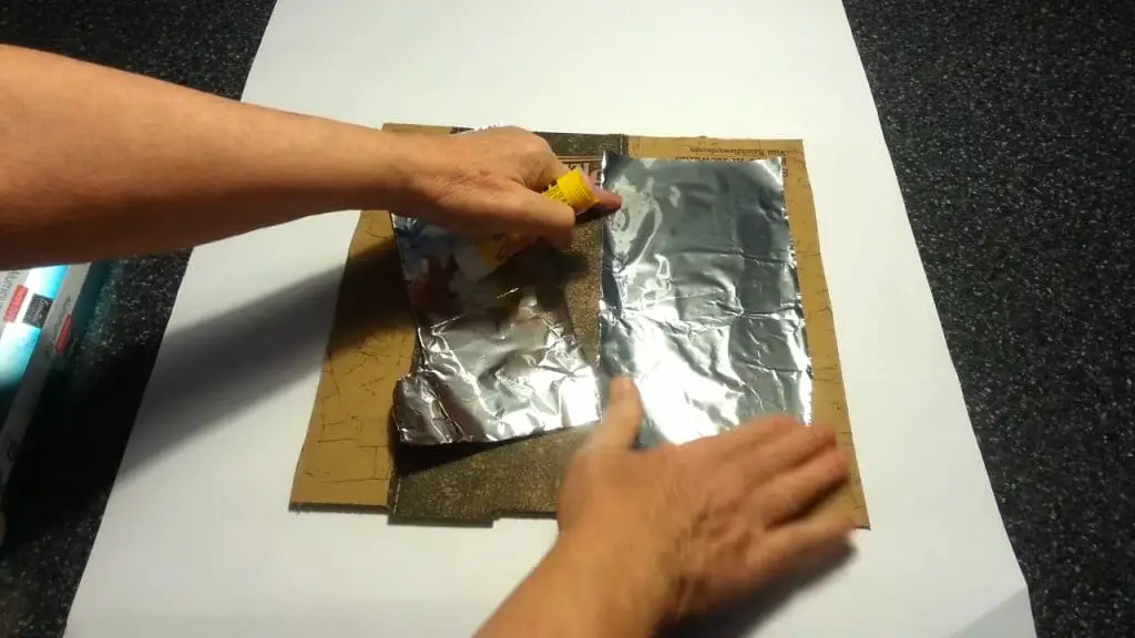 man placing aluminum foil/sheet