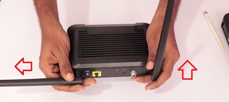 man fixing the antenna of a wifi router