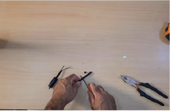 man removing the coaxial cable's core using screw and tool knife