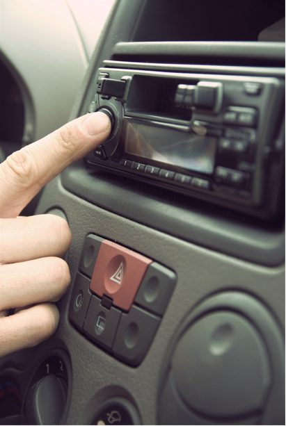 man pointing at the car stereo's setting