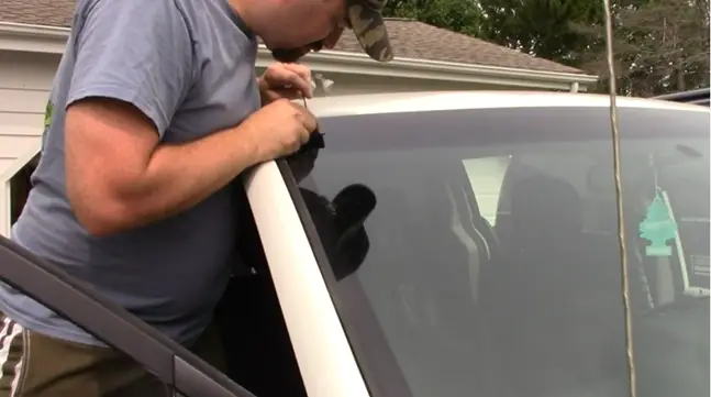 man mounting his antenna at the top of his car